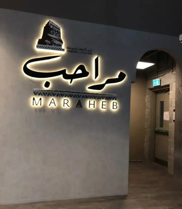 حروف بارزة لمراحب بإضاءة خلفية على حائط رمادي
